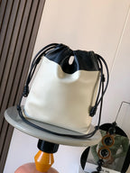 Loewe drawstring bag with black gathered top, cream body, and braided chain handle