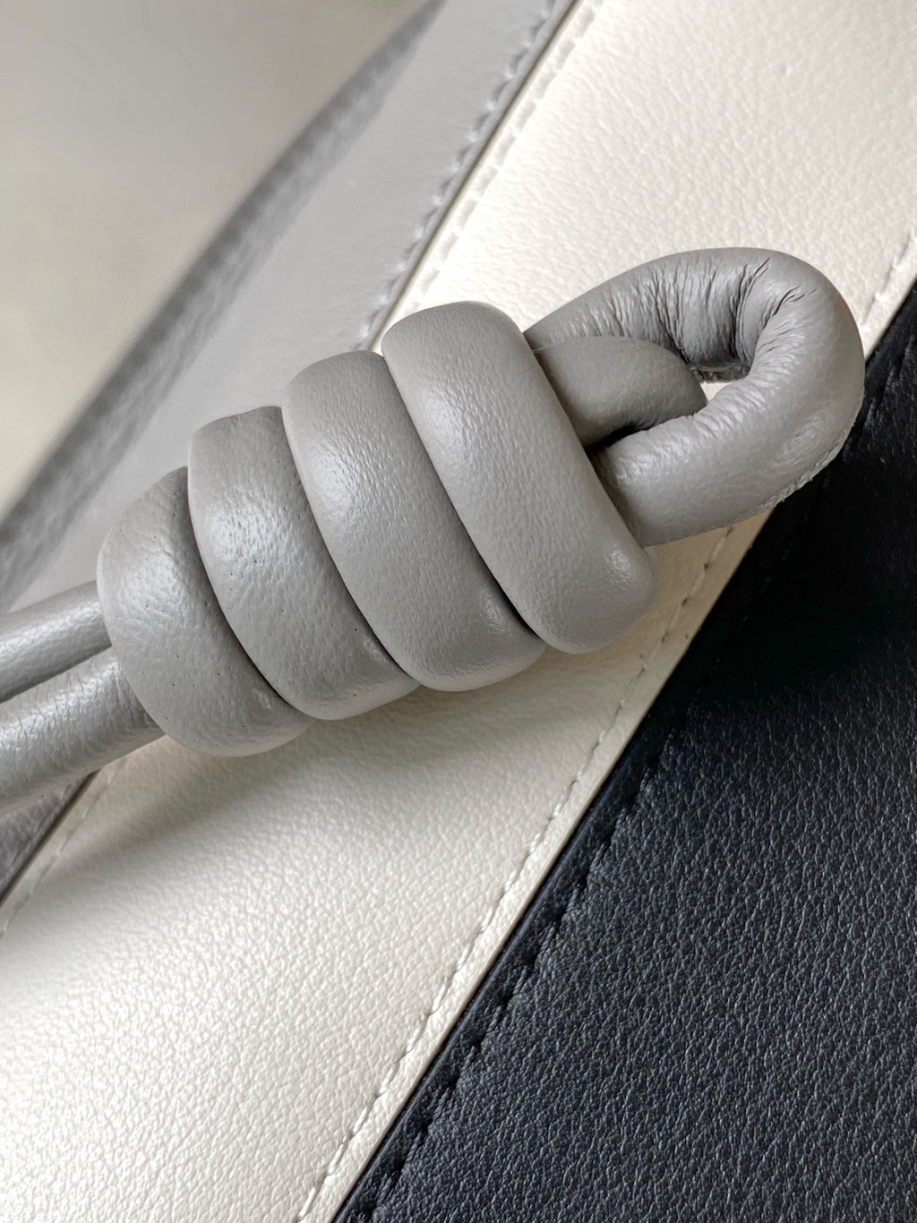Loewe leather bag handle close-up with padded top stitch, light gray
