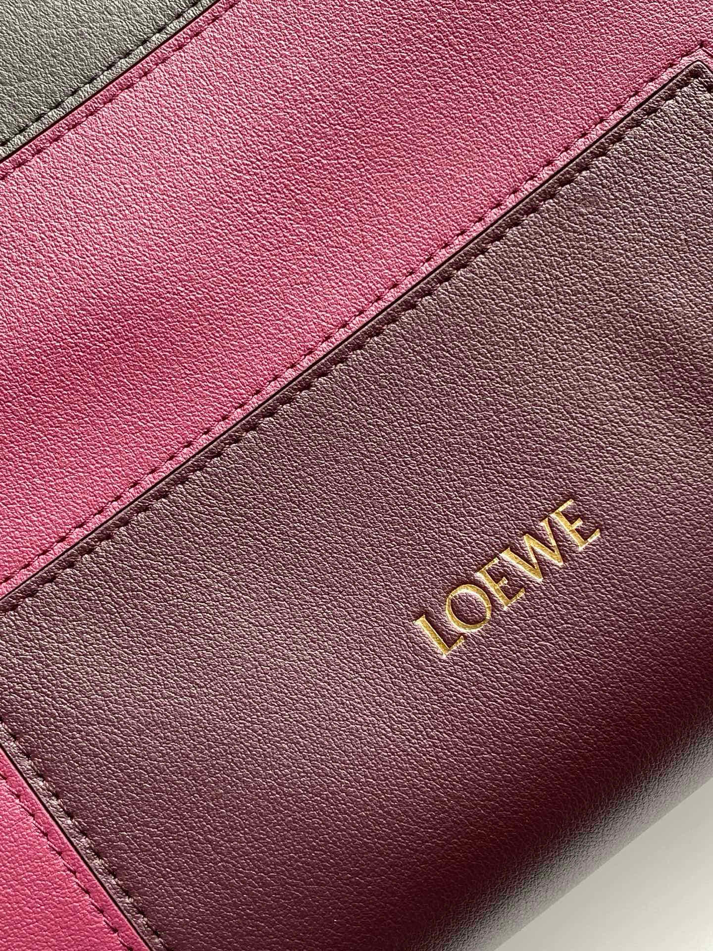 Leather bag panel close-up with pink and taupe leather and Loewe lettering