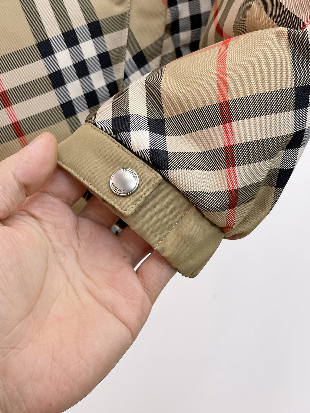 Burberry long jacket cuff detail with beige tab and snap button on plaid