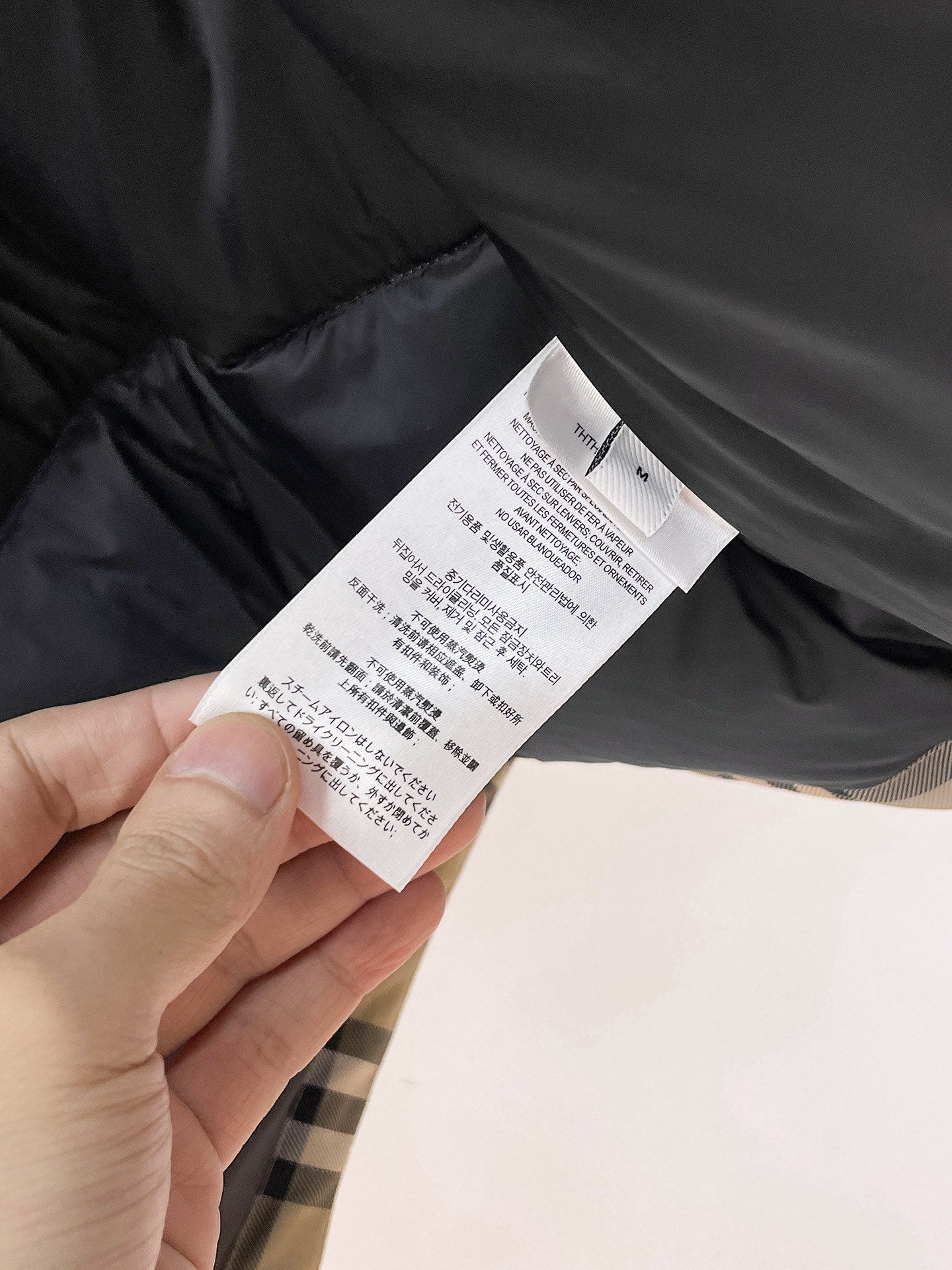 Long dark garment fabric with white care label tag