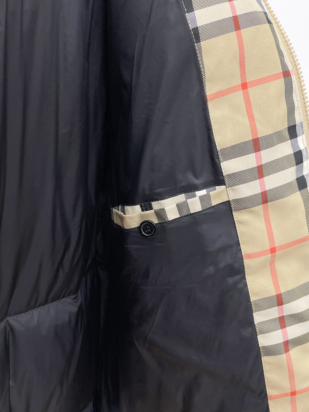 Burberry long jacket inner pocket detail, black body with plaid trim edge