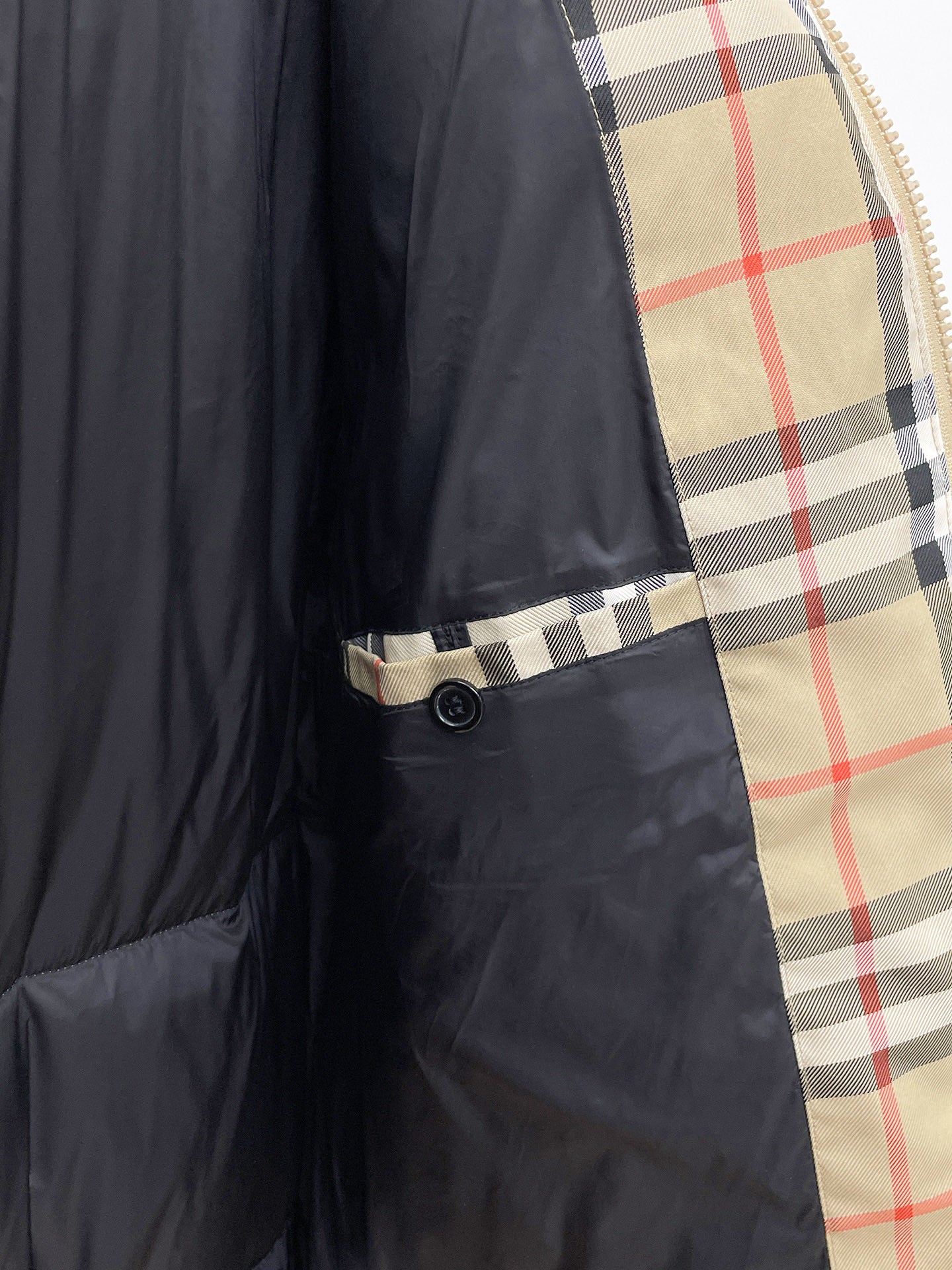 Burberry long jacket inner pocket detail, black body with plaid trim edge