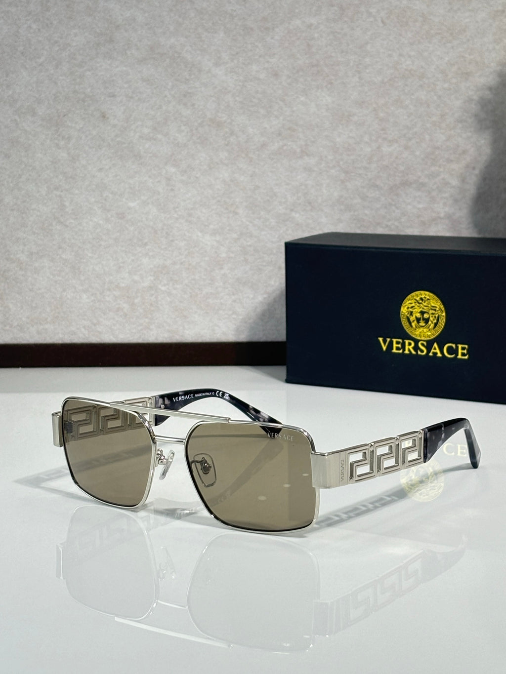 Sunglasses with gold-tone rectangular frames and brown mirrored lenses