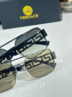 Sunglasses close-up with dark lenses and dark temples, metal Greek key accents