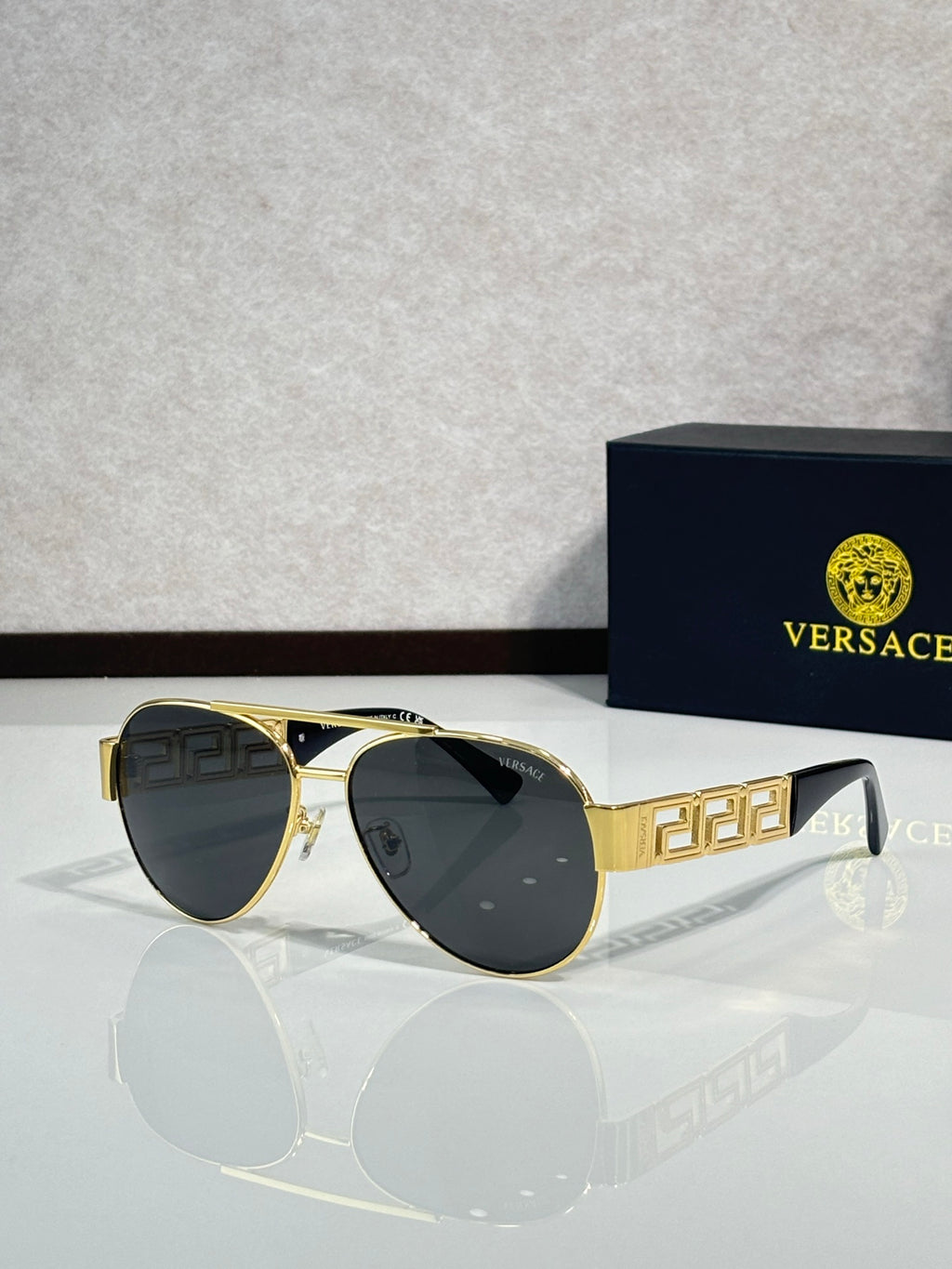 Versace aviator sunglasses with black lenses and gold frame with geometric detail