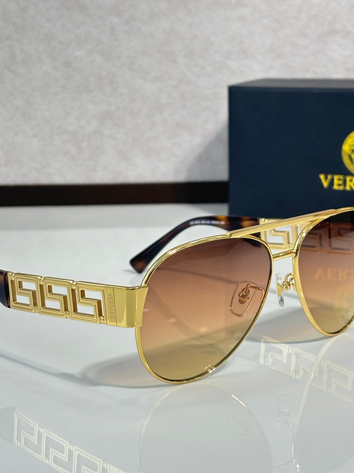 Versace aviator sunglasses with brown-tinted lenses and gold frame with logo detail