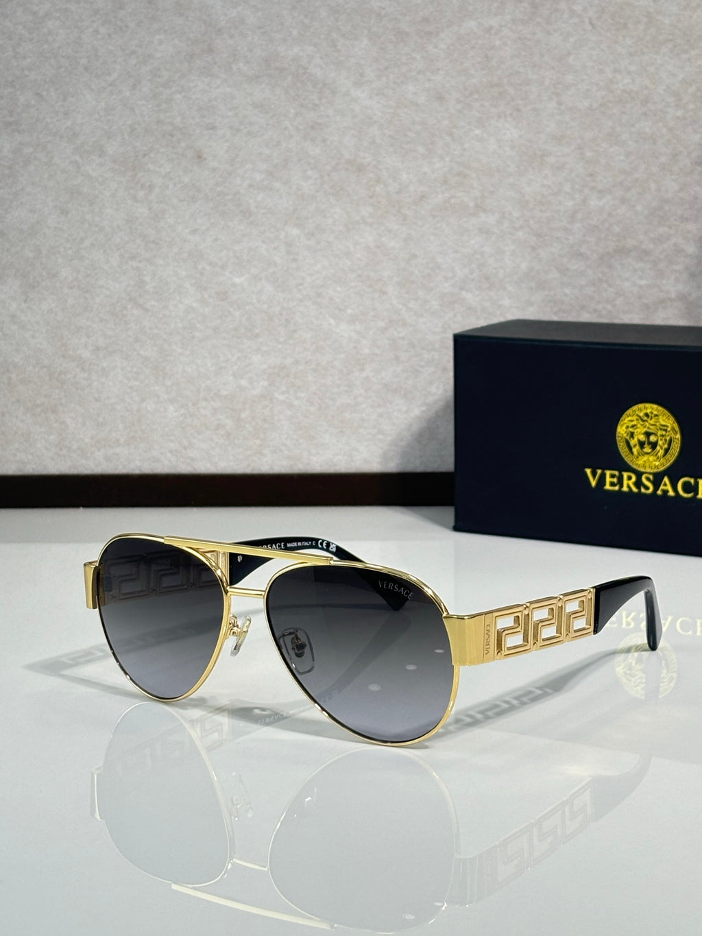 Versace aviator sunglasses with dark lenses and gold frame with emblem detail