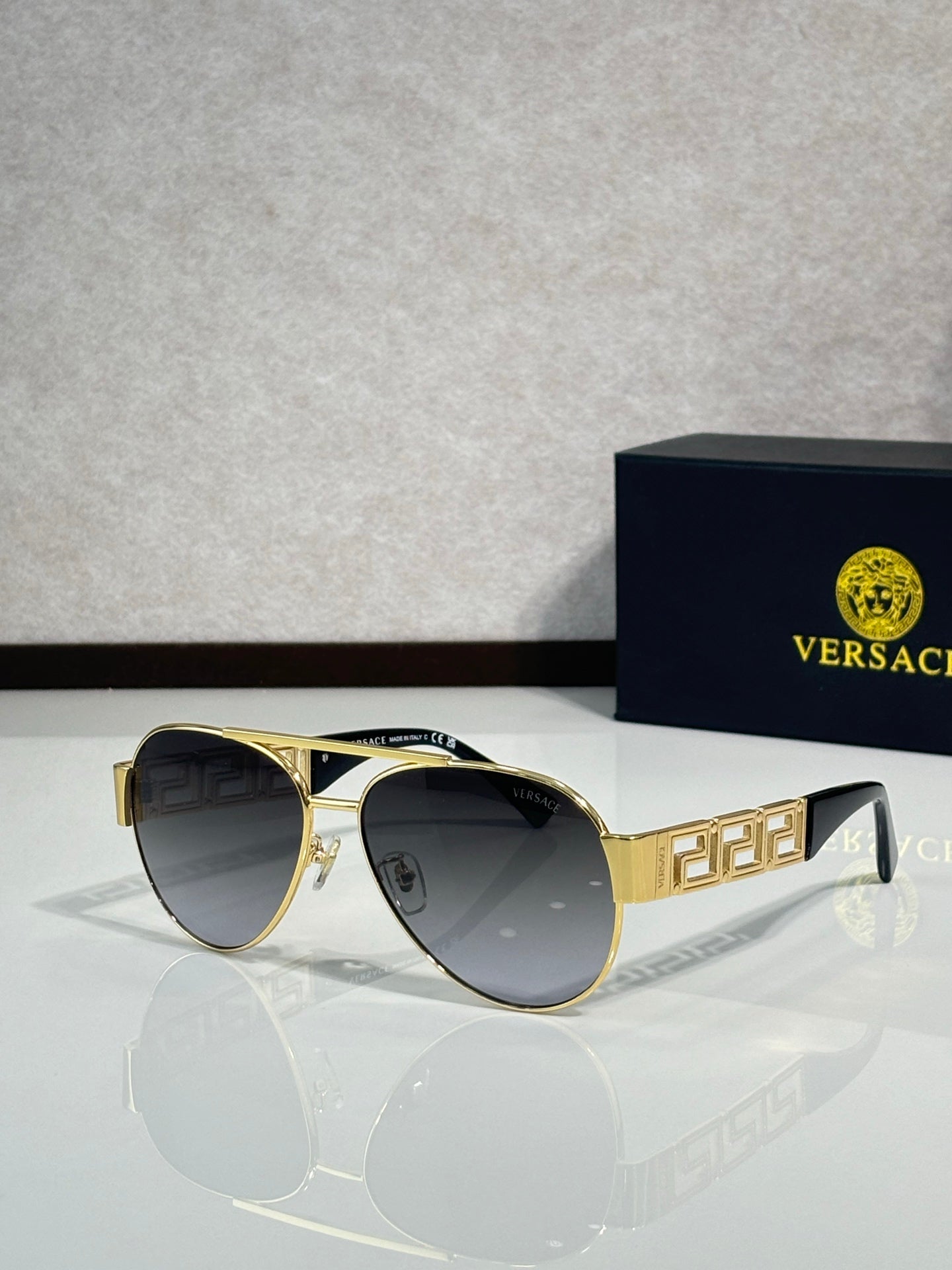 Versace aviator sunglasses with dark lenses and gold frame with emblem detail