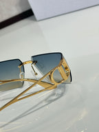 Dior sunglasses close-up of side frame and blue lenses with gold temple detail.