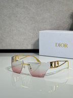 Dior sunglasses with gold frame and pink gradient lenses, side view.