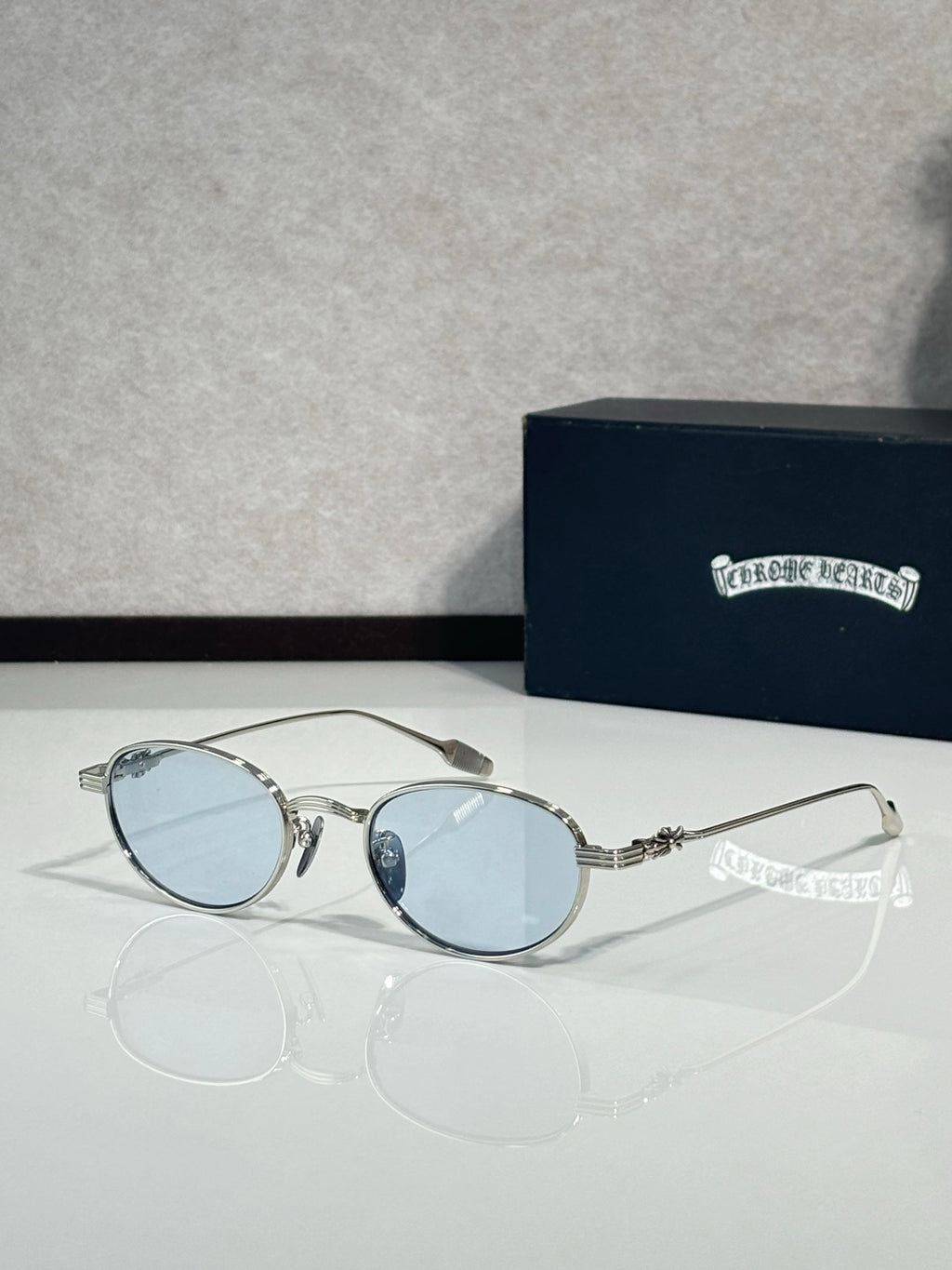 Silver-tone round sunglasses with light blue tinted lenses and metal side arms