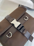 Prada brown nylon bag strap close-up with metal D-ring and buckle