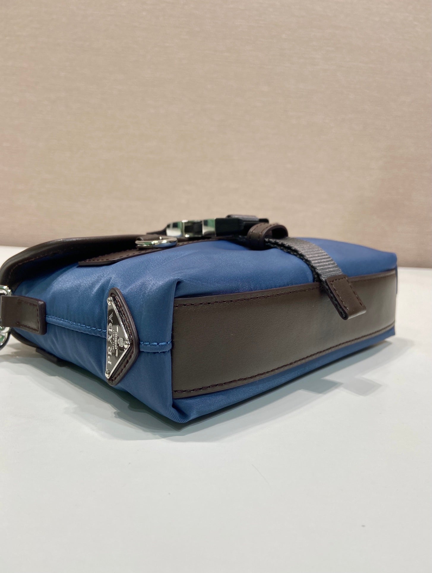 Blue and brown mini bag with top zipper, metal hardware, contrast trim