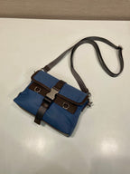 Blue small shoulder bag with flap, brown leather strap, side hardware
