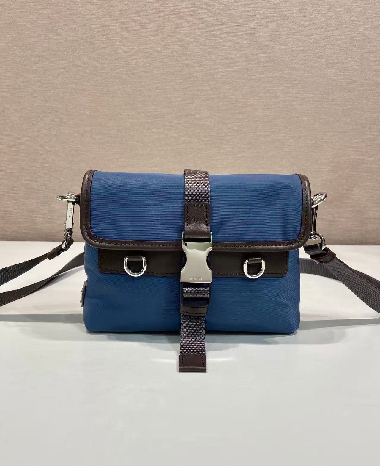 Prada blue crossbody bag with front flap and brown leather trim, buckles