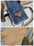 Prada logo patch on blue mini bag with brown accents and engraved hardware