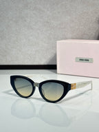 Cat-eye sunglasses with dark tortoiseshell frames, gold temple logo, tinted lenses