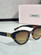 Cat-eye sunglasses angled view, dark tortoiseshell frame, tinted lenses, gold temple details