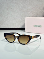 Cat-eye sunglasses with dark tortoiseshell frames, gold temple logo, tinted lenses