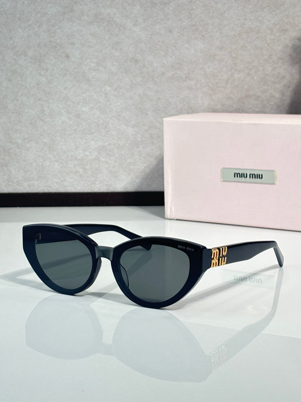 Cat-eye sunglasses with dark tortoiseshell frames, tinted lenses, clear temple tips