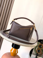 Dark brown leather small handbag with top handle, crossbody strap, and gold-tone zipper