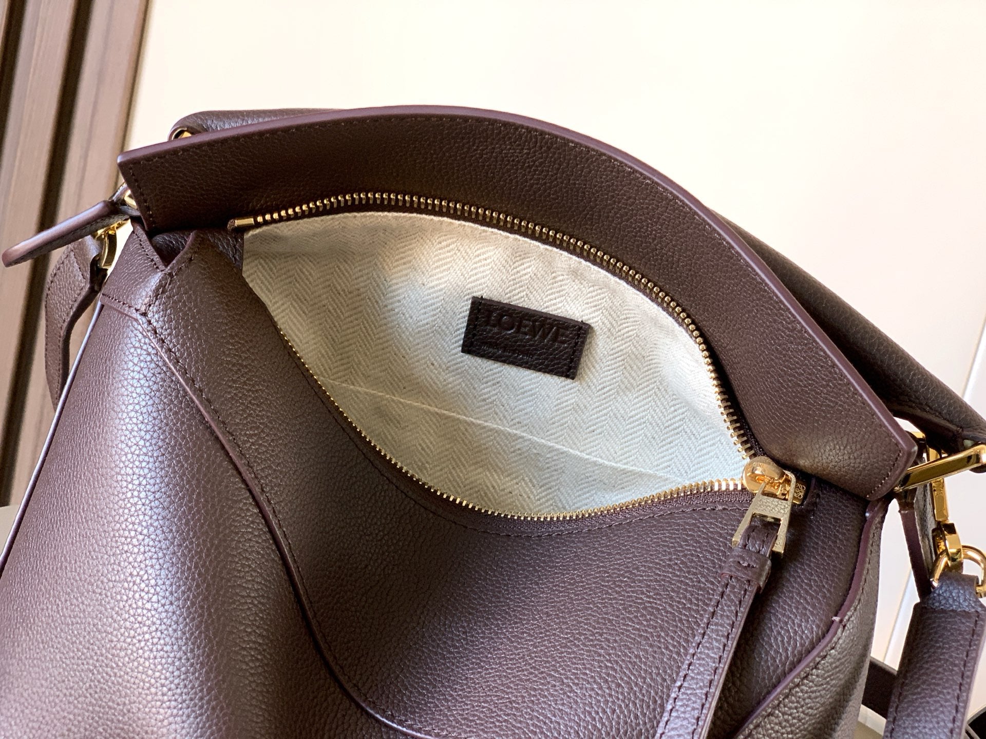 Dark brown leather bag interior with beige lining and LOEWE label