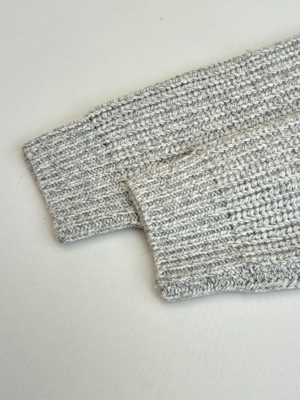 Stone Island knit fabric close-up with light gray ribbed cuff and hem detail