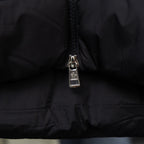 Long black puffer coat with front zipper close-up