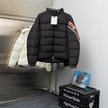 Black long puffer jacket with high collar and hood, front zipper, tag attached
