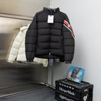 Black long puffer jacket with high collar and hood, front zipper, tag attached
