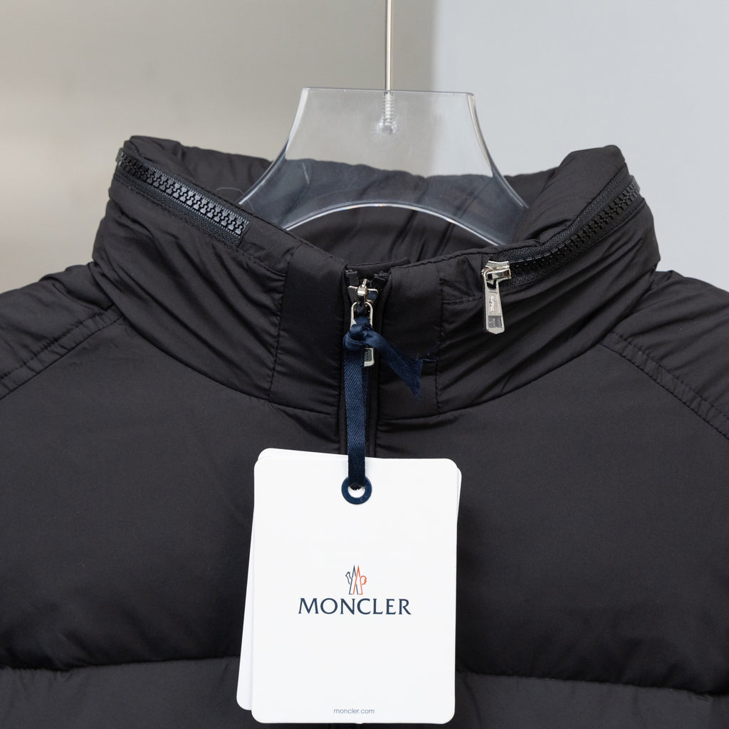 Black puffer jacket with stand collar, front zipper and MONCLER hang tag