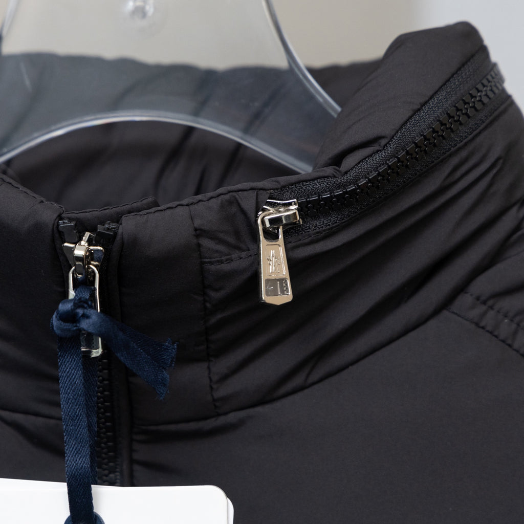 Black puffer jacket front with metal zipper and stand collar, blue pull detail