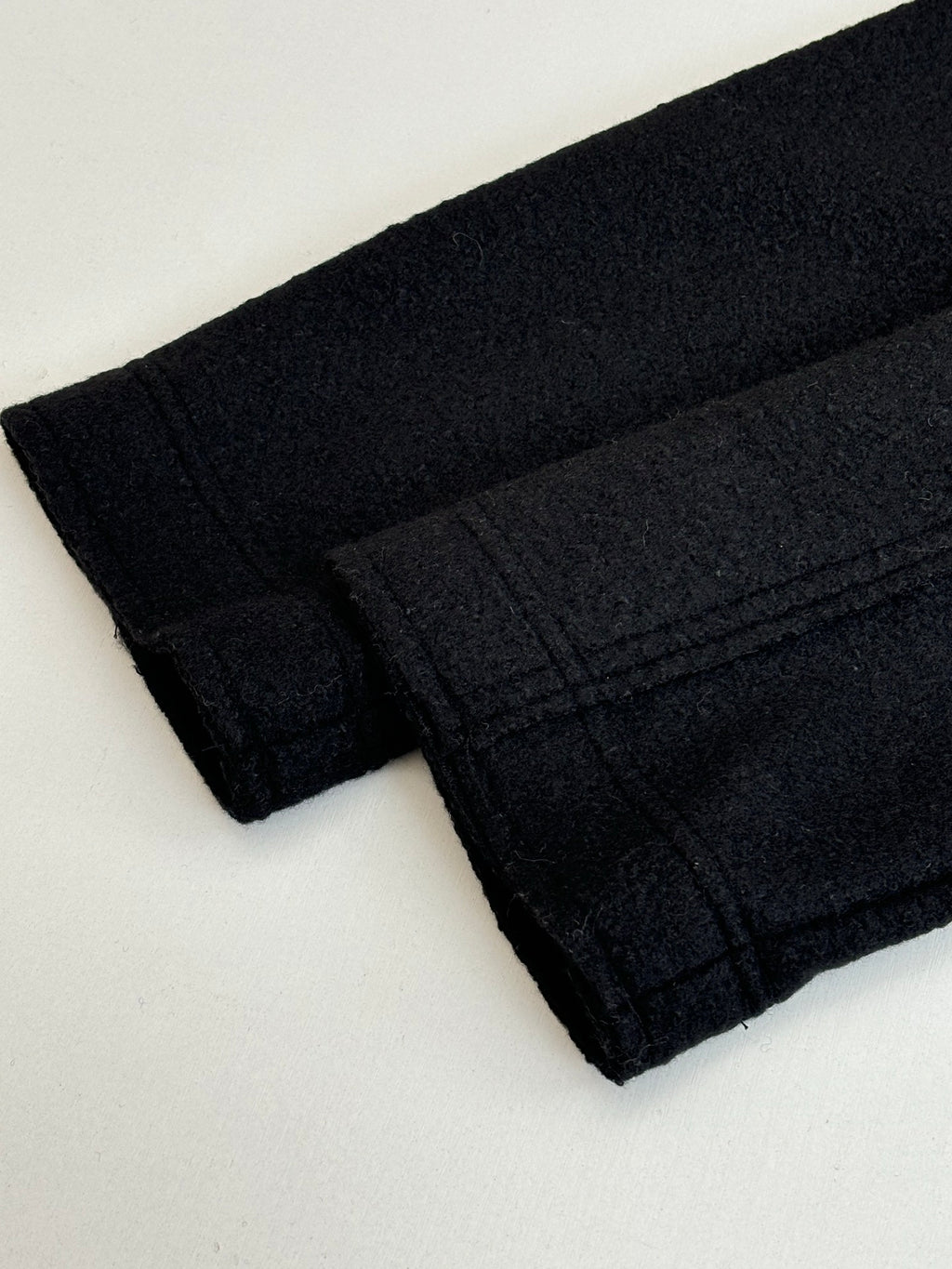 Dark jacket fabric cuff and sleeve hem with stitched seams
