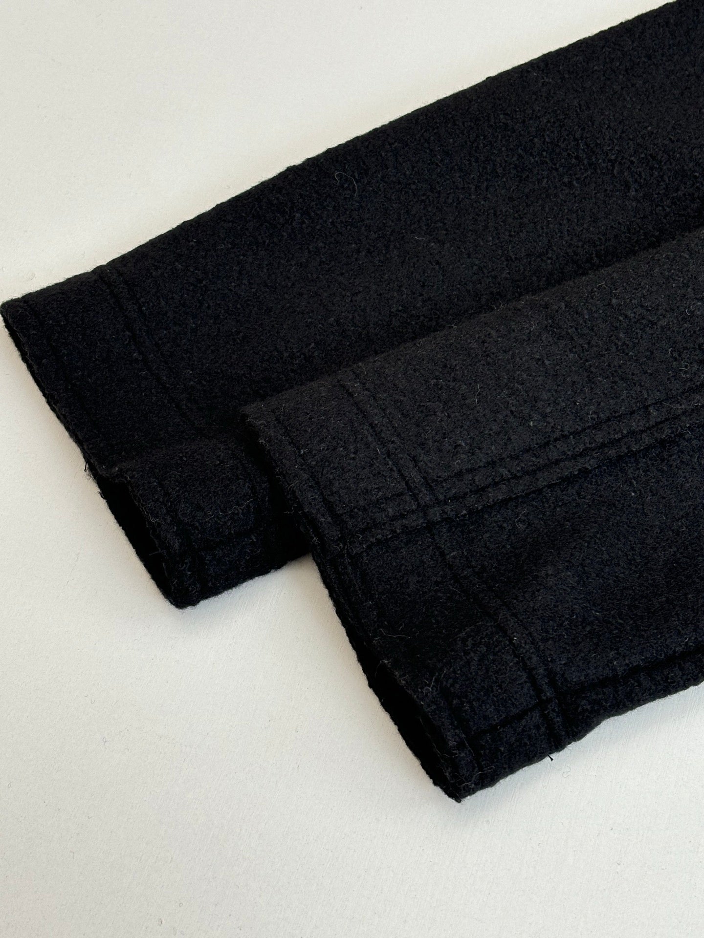 Dark jacket fabric cuff and sleeve hem with stitched seams