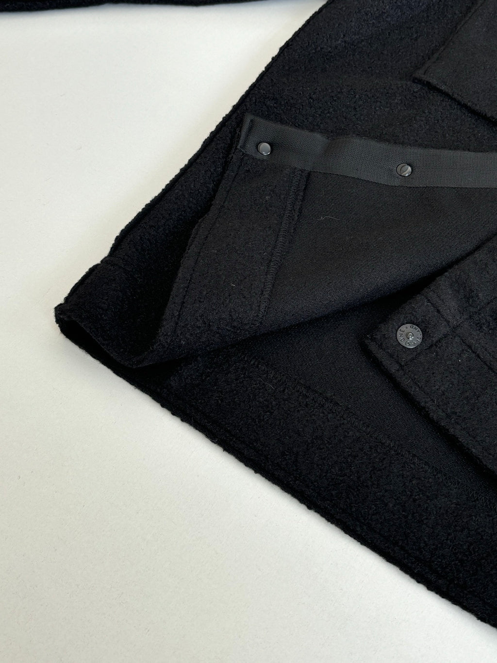 Dark jacket sleeve cuff with button detail and inner placket