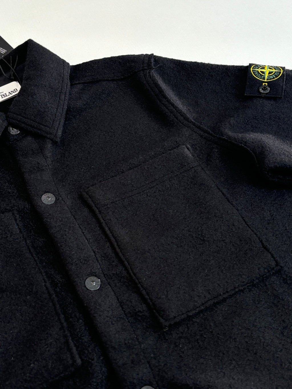 Dark button-up jacket chest area with front pockets and visible button placket