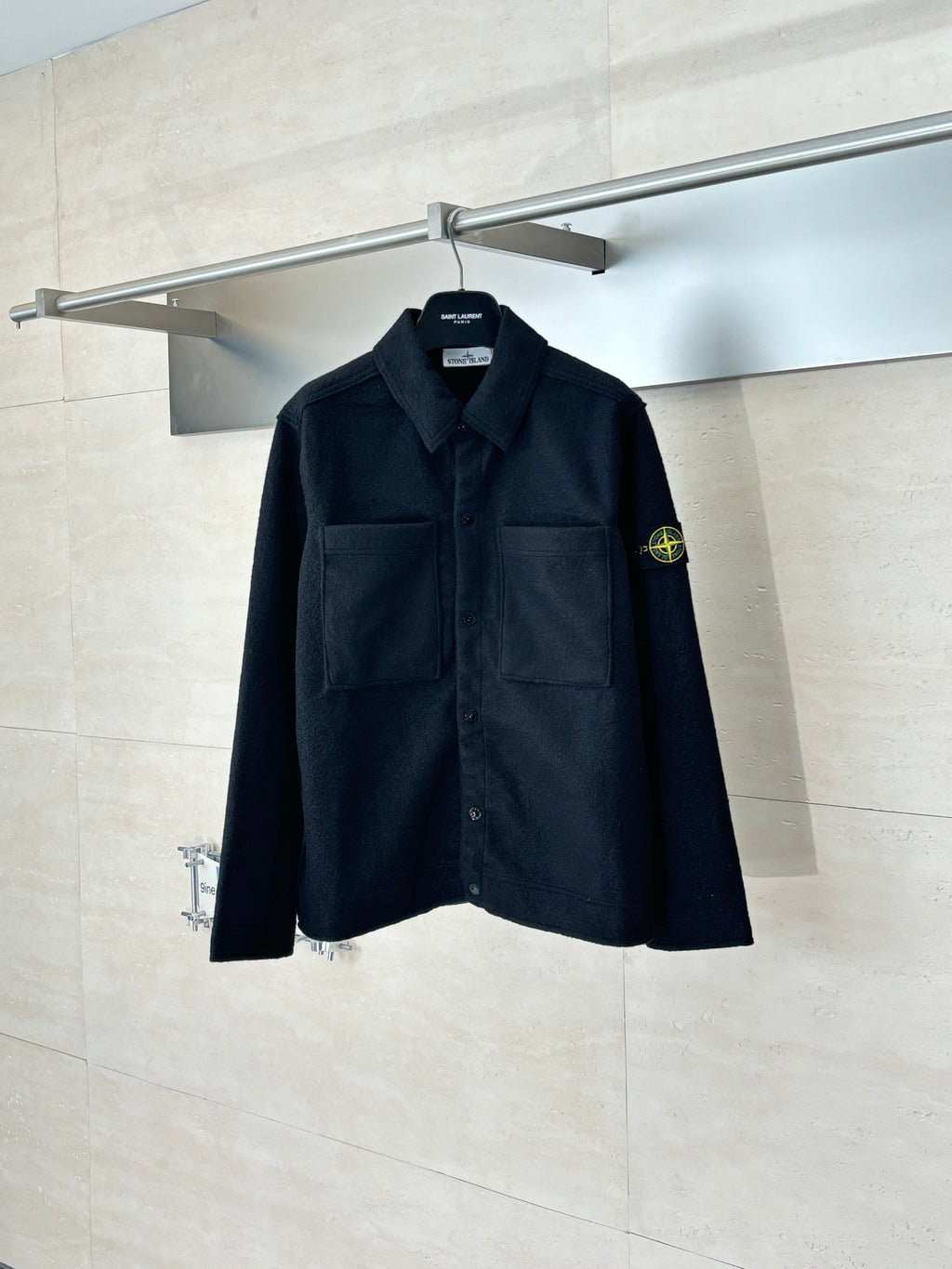 Dark button-up jacket with chest pockets and Stone Island logo patch on sleeve