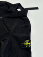 Dark jacket shoulder and chest with Stone Island logo patch