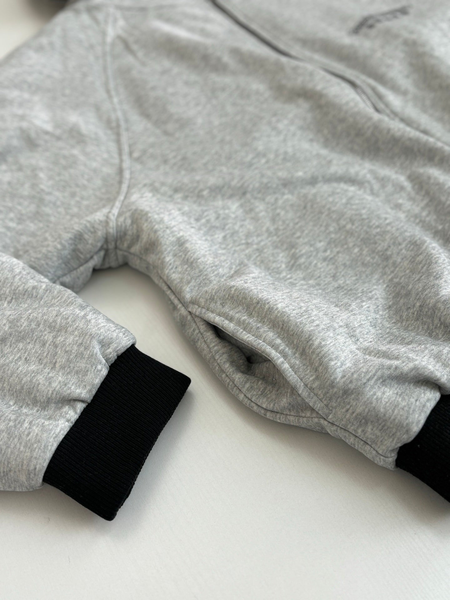 Heather gray zip-up hoodie sleeve and hood with black ribbed cuff