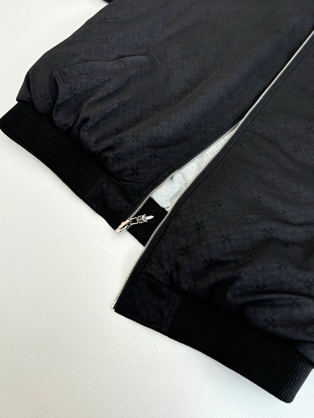 Black zip-up hoodie with textured fabric and silver zipper