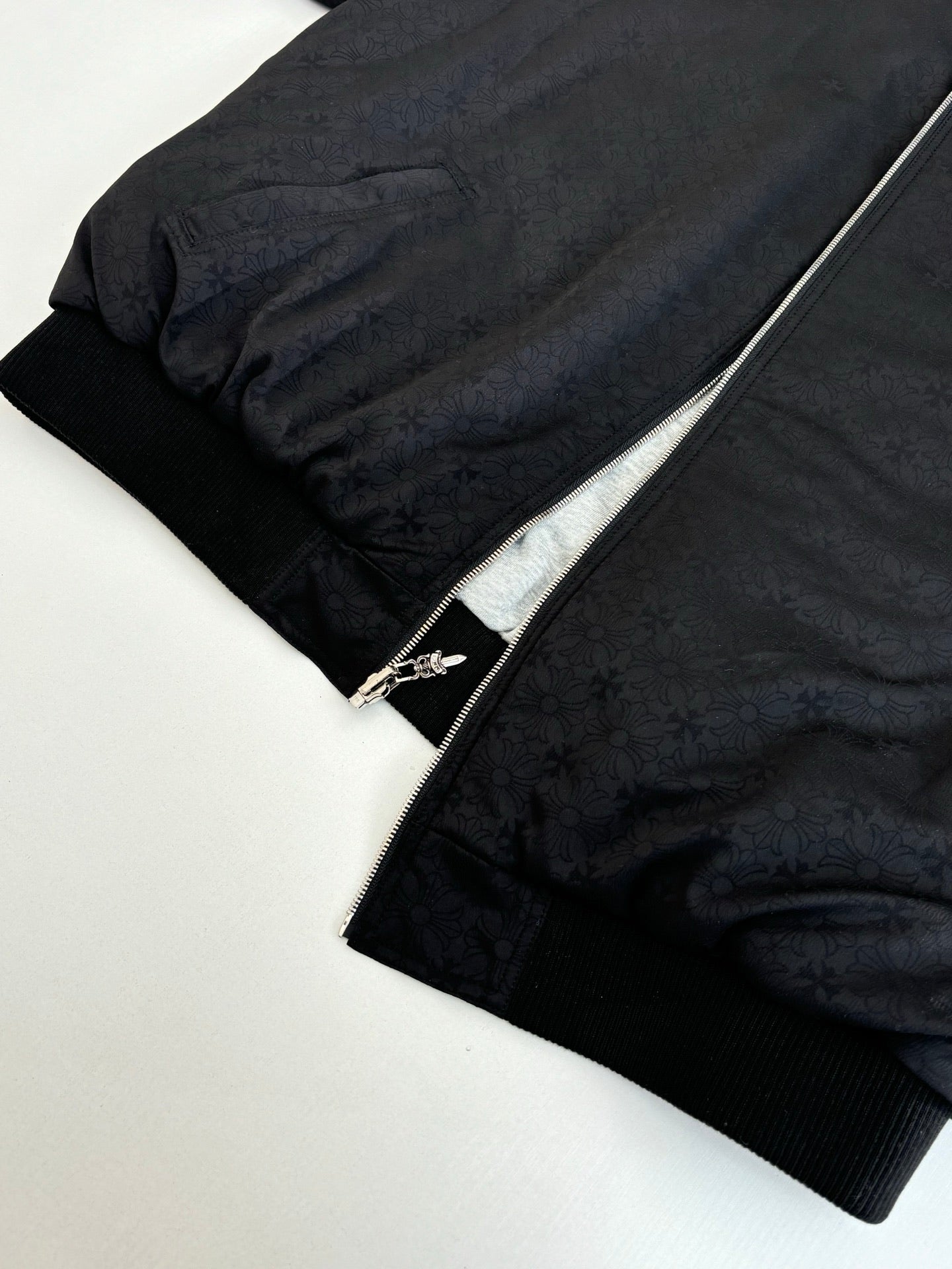 Black zip-up hoodie with textured fabric and silver zipper