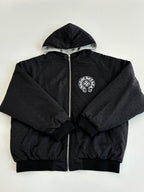 Black zip-up hoodie with hood and round chest emblem patch
