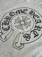Gray hoodie front close-up of black circular graphic and floral icon