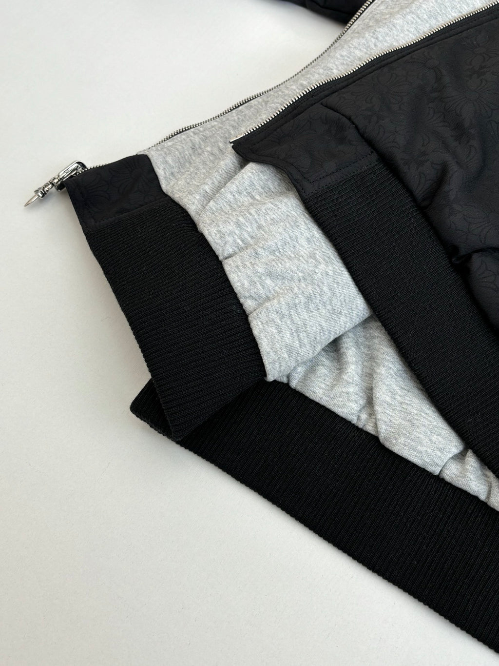 Black hoodie hem with ribbed cuffs and gray inner lining