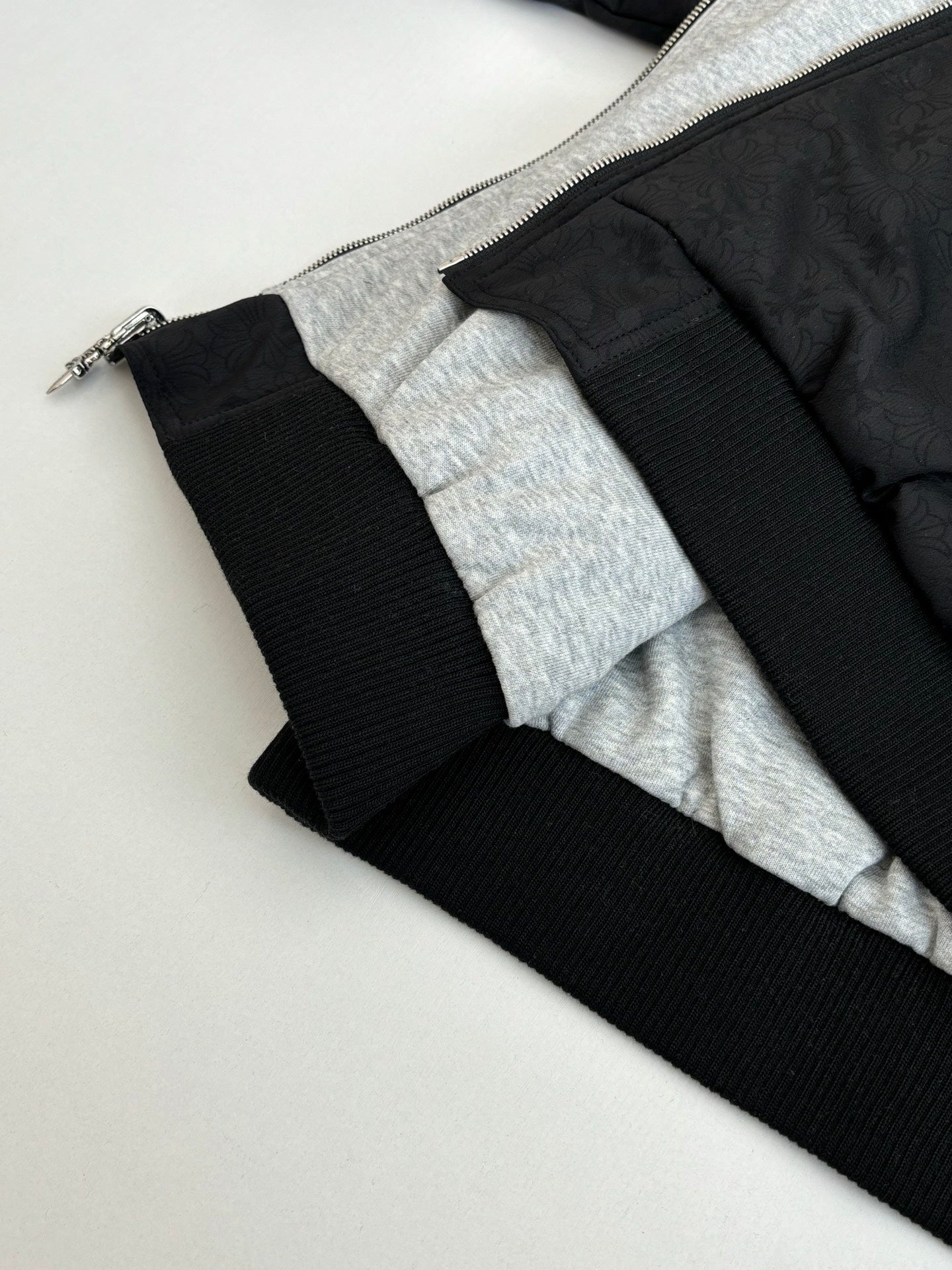 Black hoodie hem with ribbed cuffs and gray inner lining