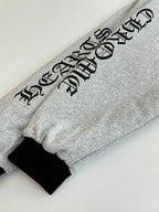 Gray hoodie sleeve with black graphic lettering and black cuff
