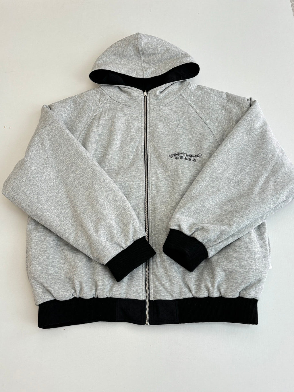 Heather gray zip-up hoodie with hood and small chest emblem, black ribbed cuffs