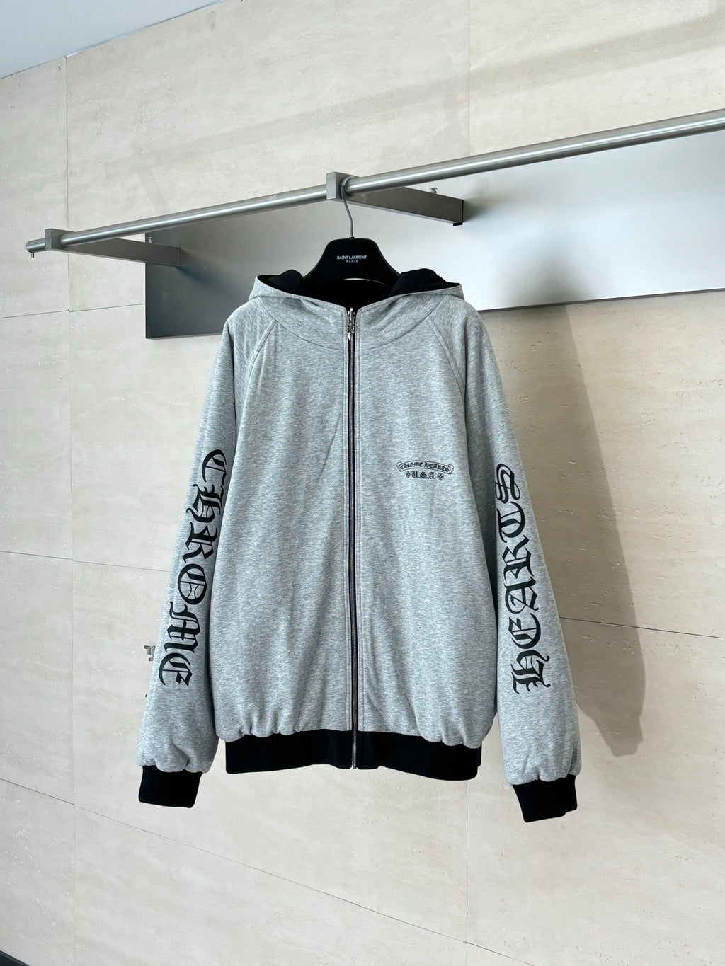 Heather gray zip-up hoodie with hood, black trim, and sleeve logo print on cuffs