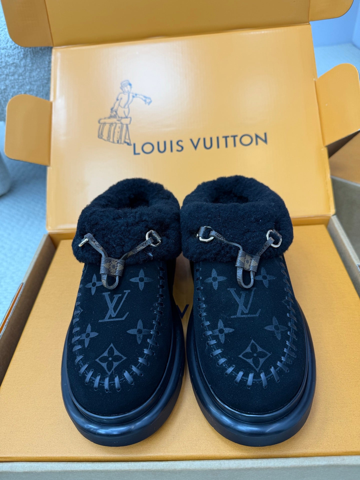 Ladies slip-on shoes with plush cuff, dark monogram upper, buckle strap, rubber sole